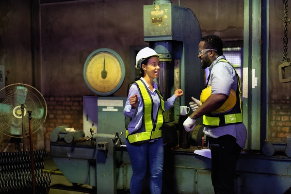 Illustration of engaged manufacturing employees in a factory setting, with visual indicators of productivity, safety, and teamwork