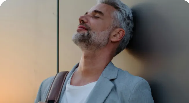 Company Formation In Dubai: Professional businessman leaning against wall, eyes closed
