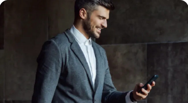 Professional businessman smiling while checking phone, Company Formation In Dubai