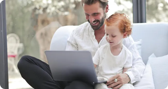 Company Formation In Dubai: Father and child working together on laptop