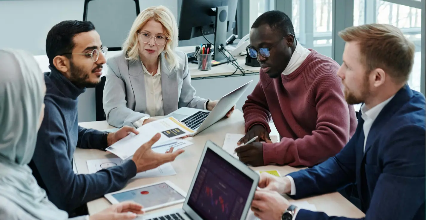 Free Zone In Dubai: Diverse Business Team Collaborating On Laptops