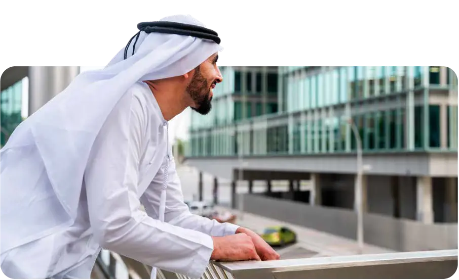 Establish Company In Dubai: Businessman in traditional attire overlooking modern building