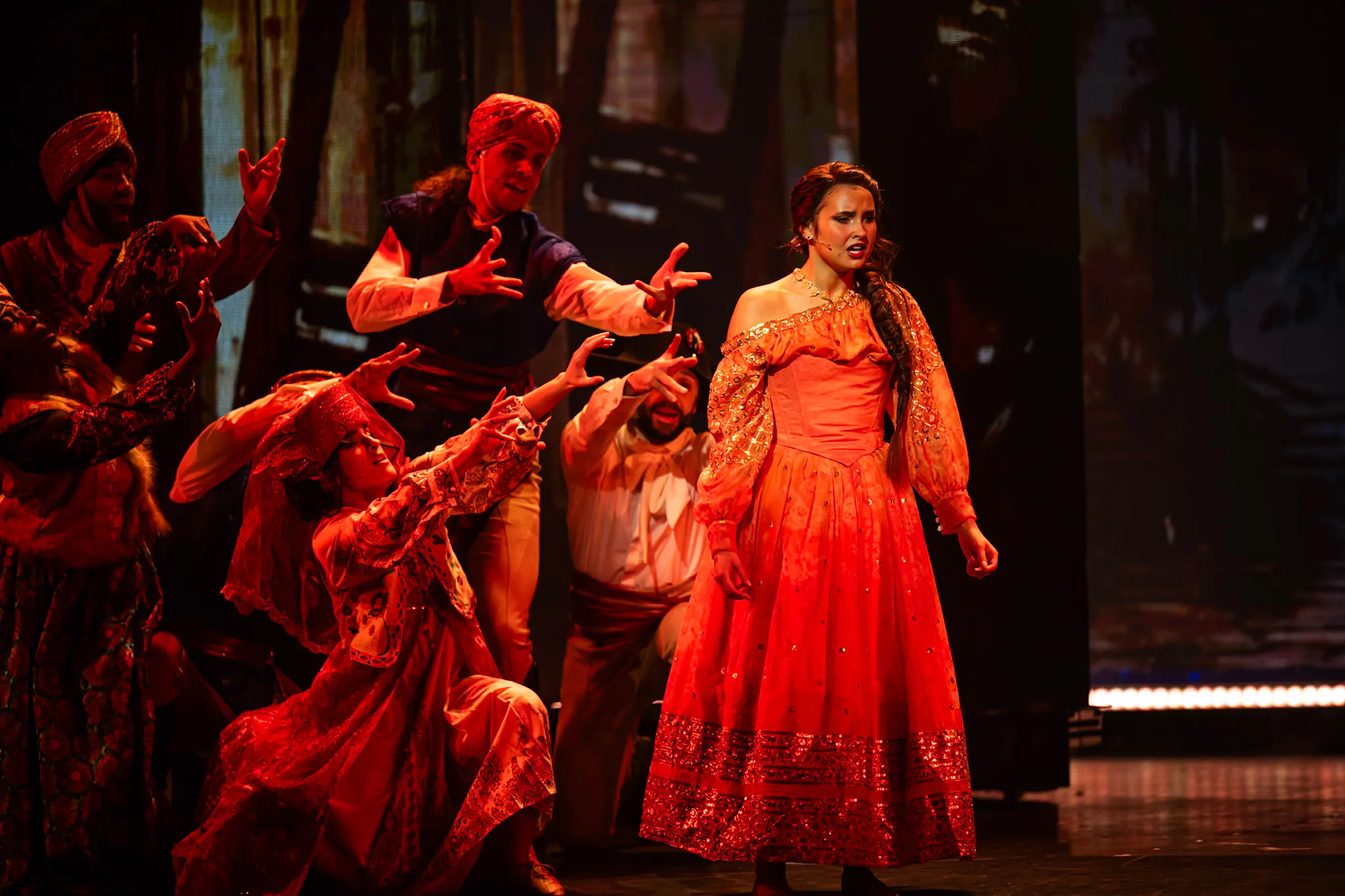 Une femme sur scène vêtue d'une robe rouge.