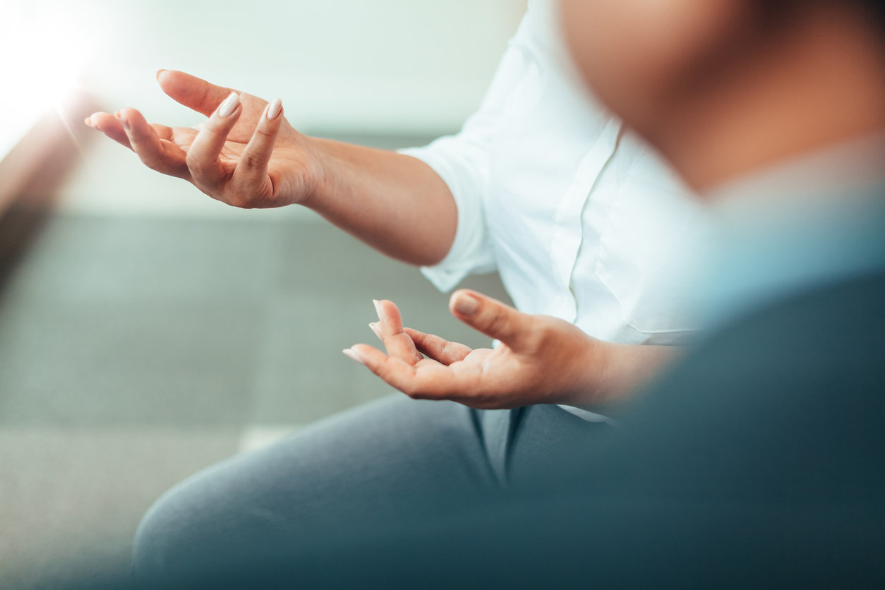 Close up image of a woman's hands as she speaks during a meeting.