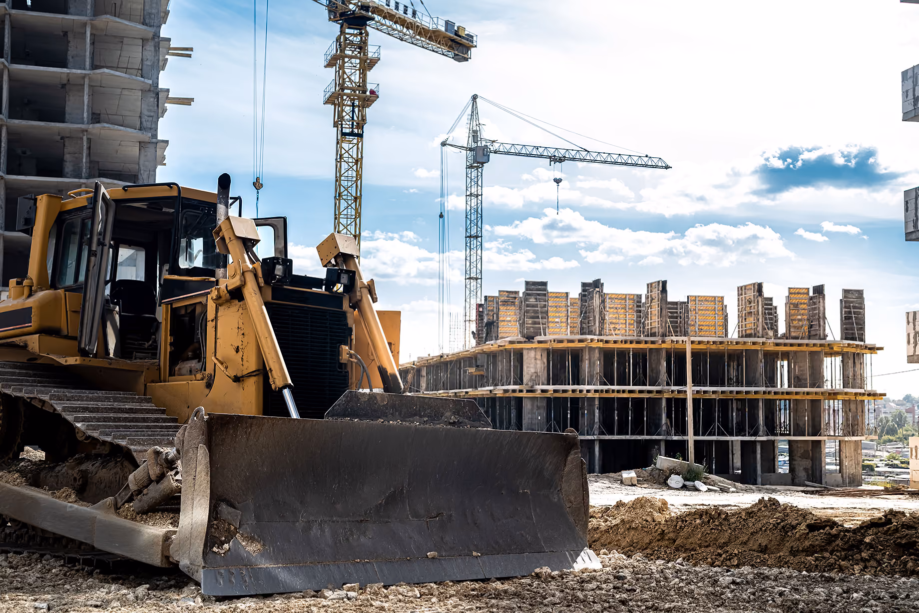Baustelle mit Bagger und Baukränen beim Neubau eines Gebäudes