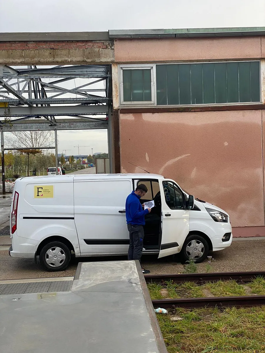 Mitarbeiter vor einem Firmenfahrzeug