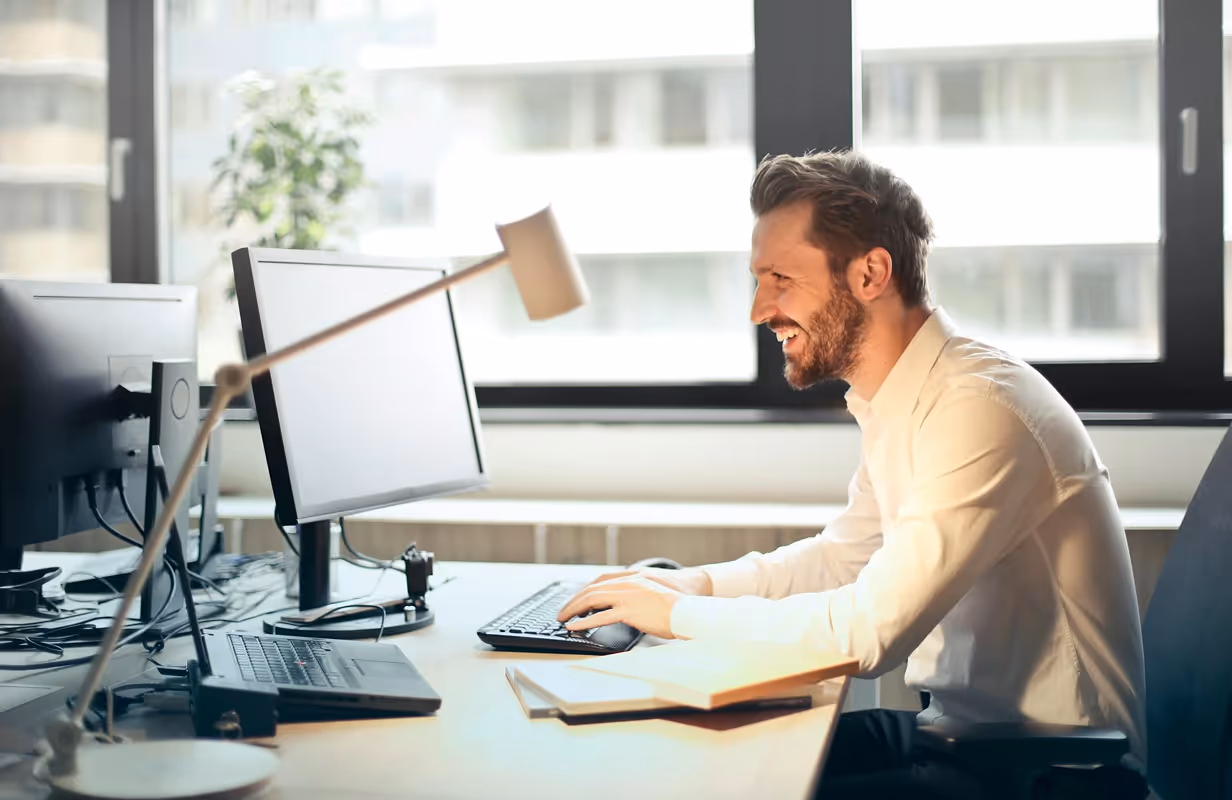 Man working on computer smiling.