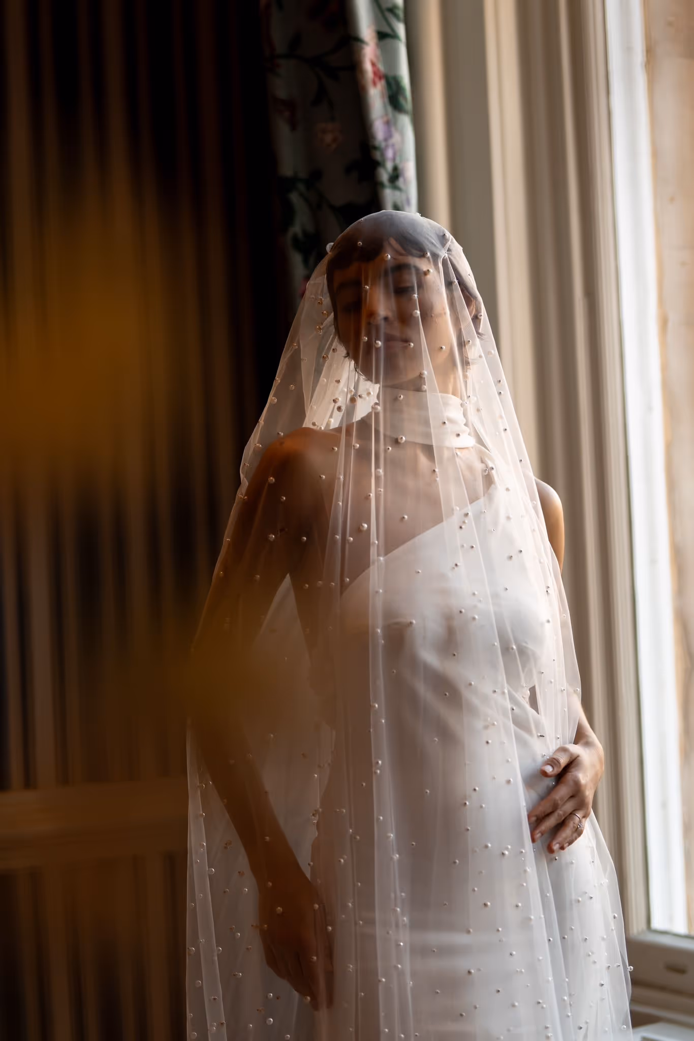 Bride in wedding dress under a pearl veil