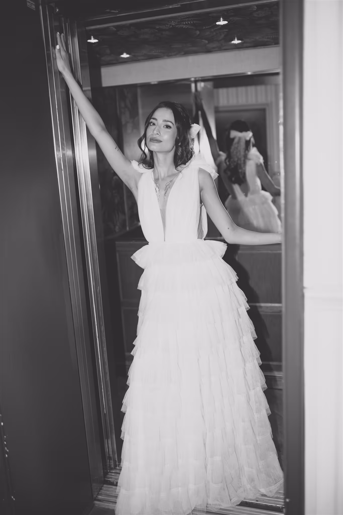 Bride wearing a wedding dress posing in a lift with mirrored background
