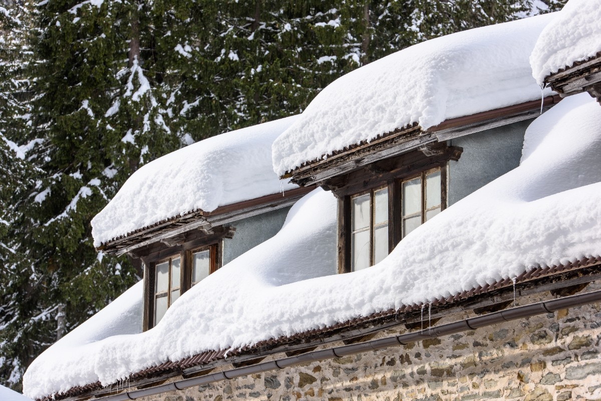 A roof of a Salt Lake City property covered with heavy snow that can cause damage