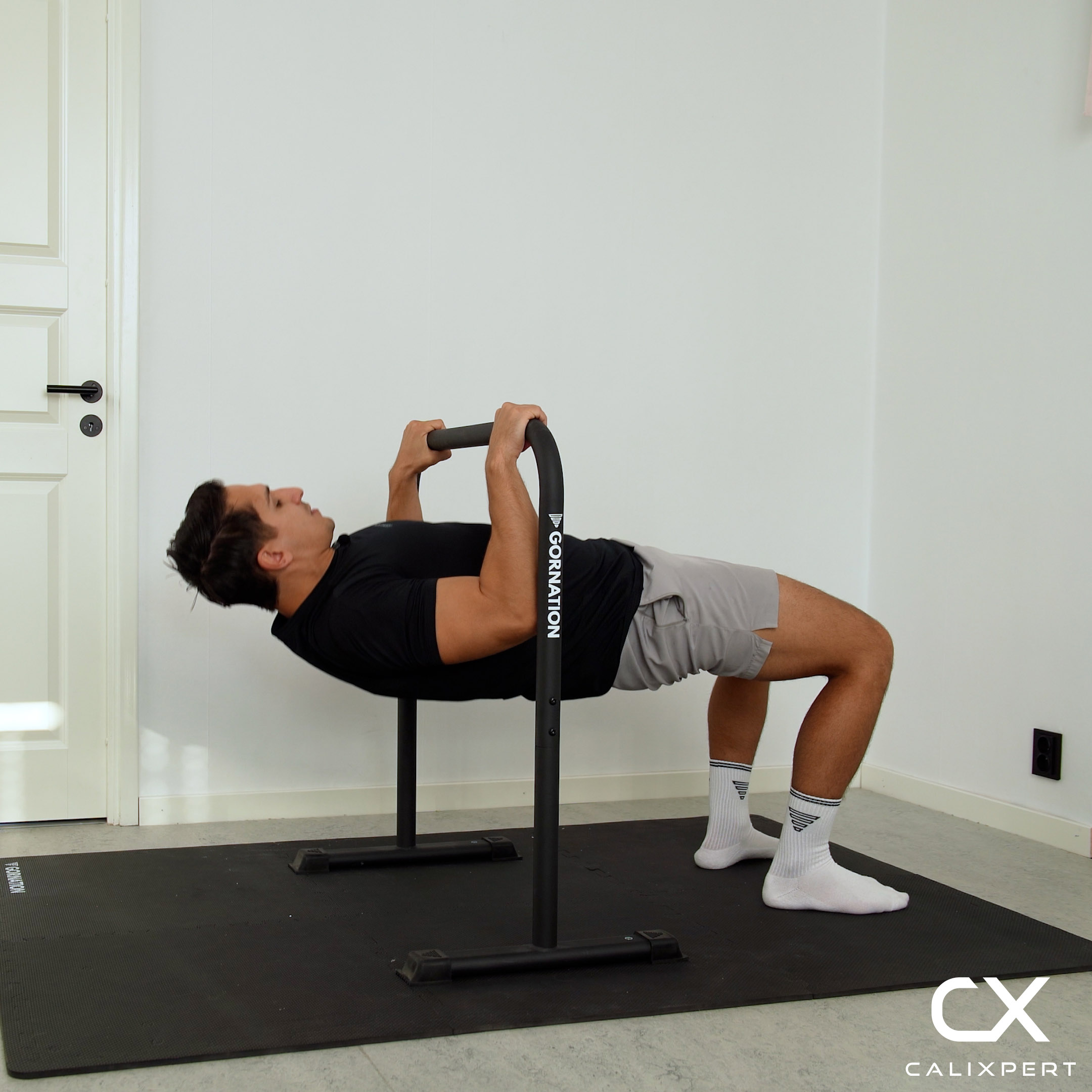 A man doing bodyweight rows under a dip bar
