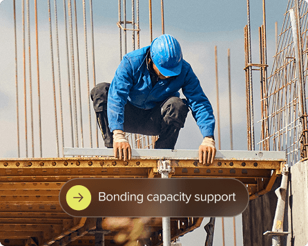 Man in a hardhat perched on platform.