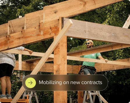 People working on a wooden frame with overlay of mobilizing on new contracts.