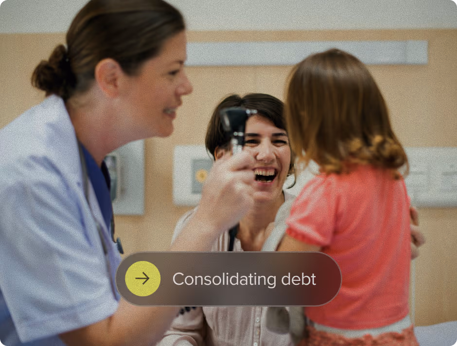 A female doctor holding a medical instrument interacts with a smiling woman and a young girl in a clinic setting.