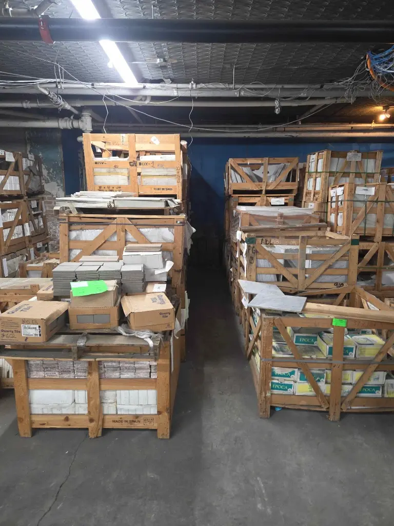 Pallets of crated tile and stone in warehouse – Stone City Auction