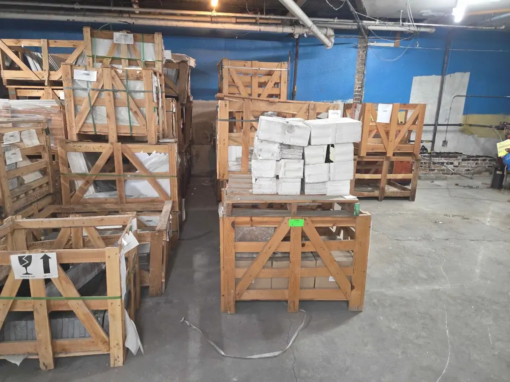Crated tile and stone inventory on pallets – Stone City Auction warehouse