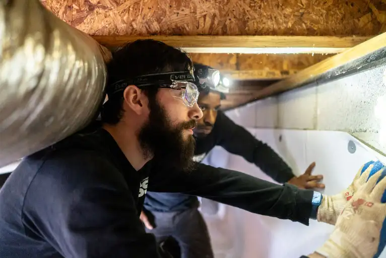 USS Foundation Repair Technician Inspecting Home Foundation 