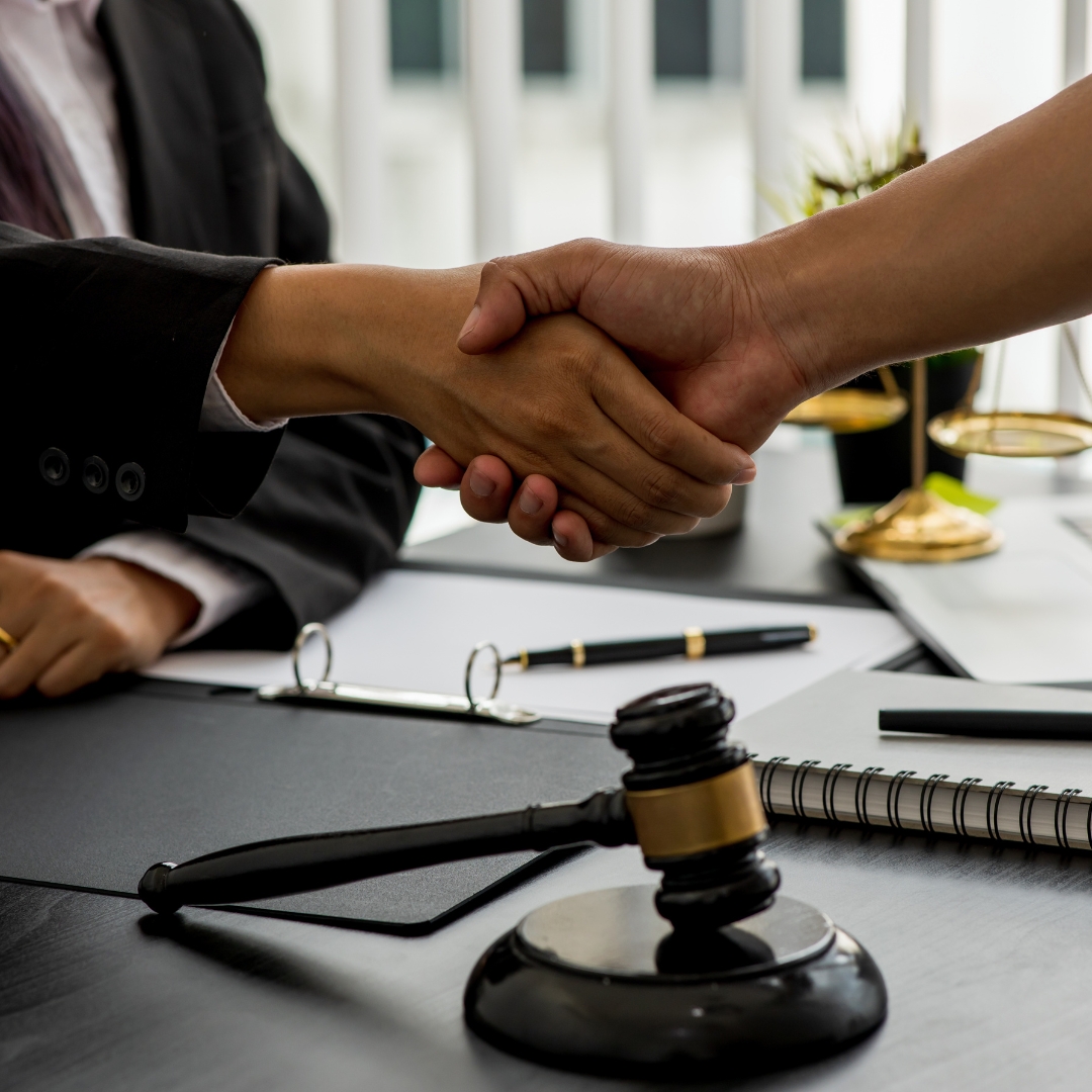 A lawyer and client shaking hands in agreement