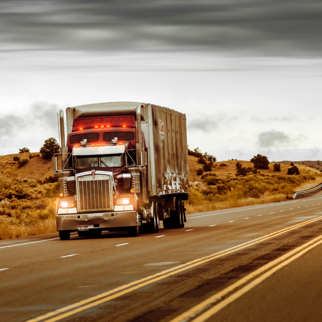 A semi-truck and trailer on a desert highway