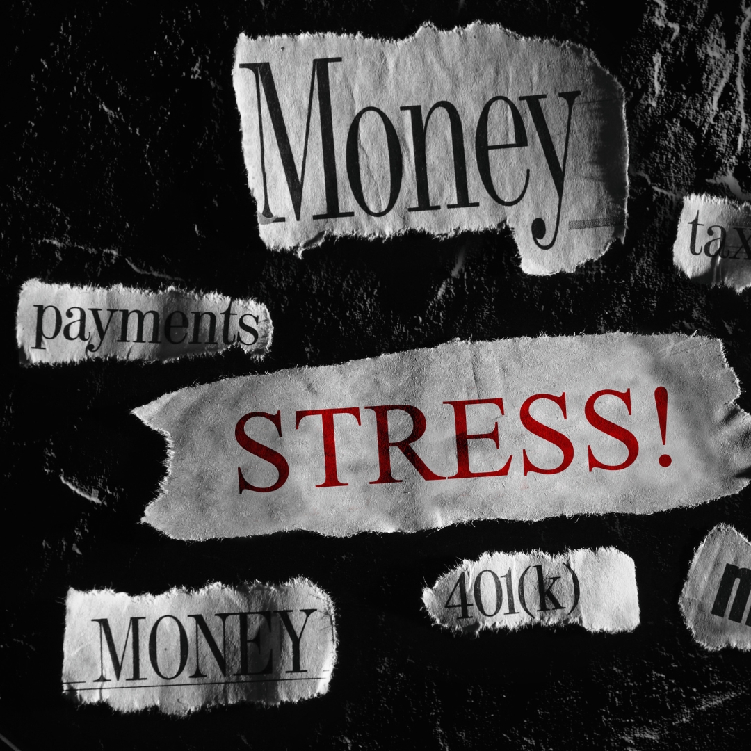Torn pieces of paper with with financial words on them, and one that says "stress"