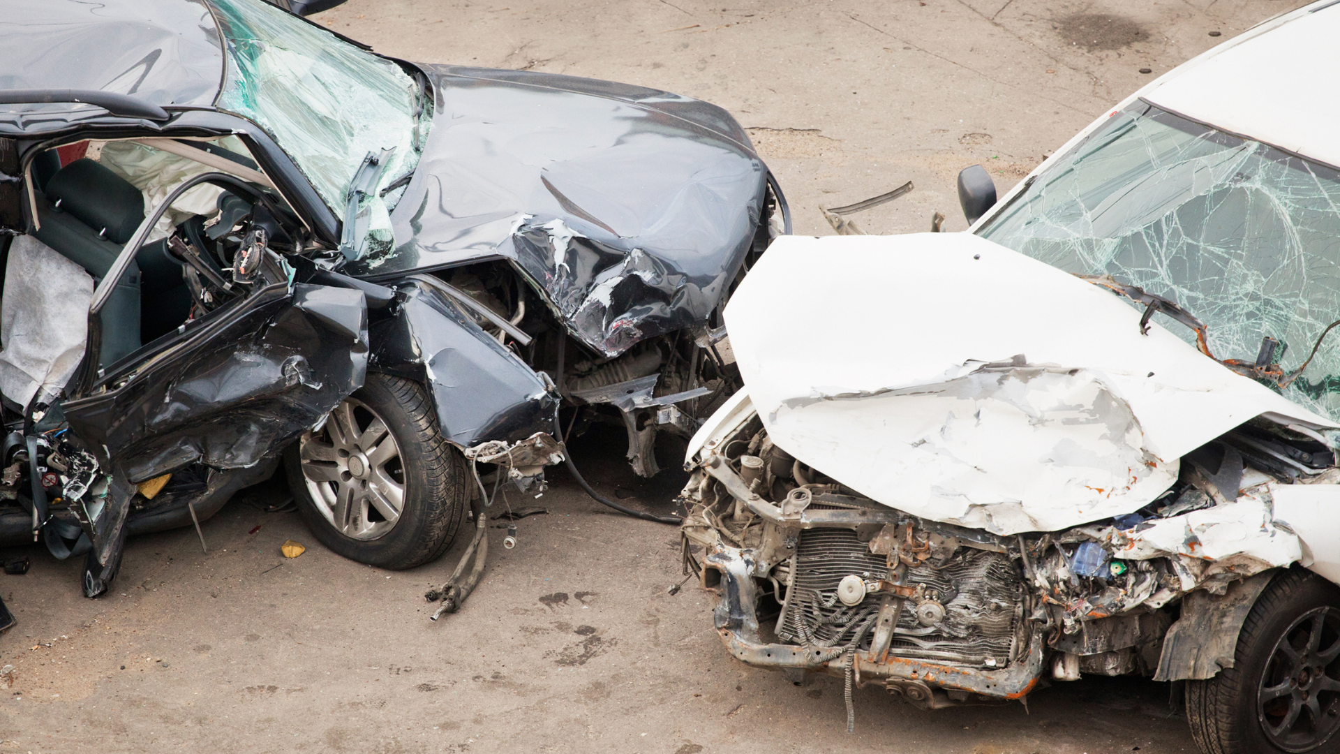 two cars in that have been severely damaged in a head on collision.