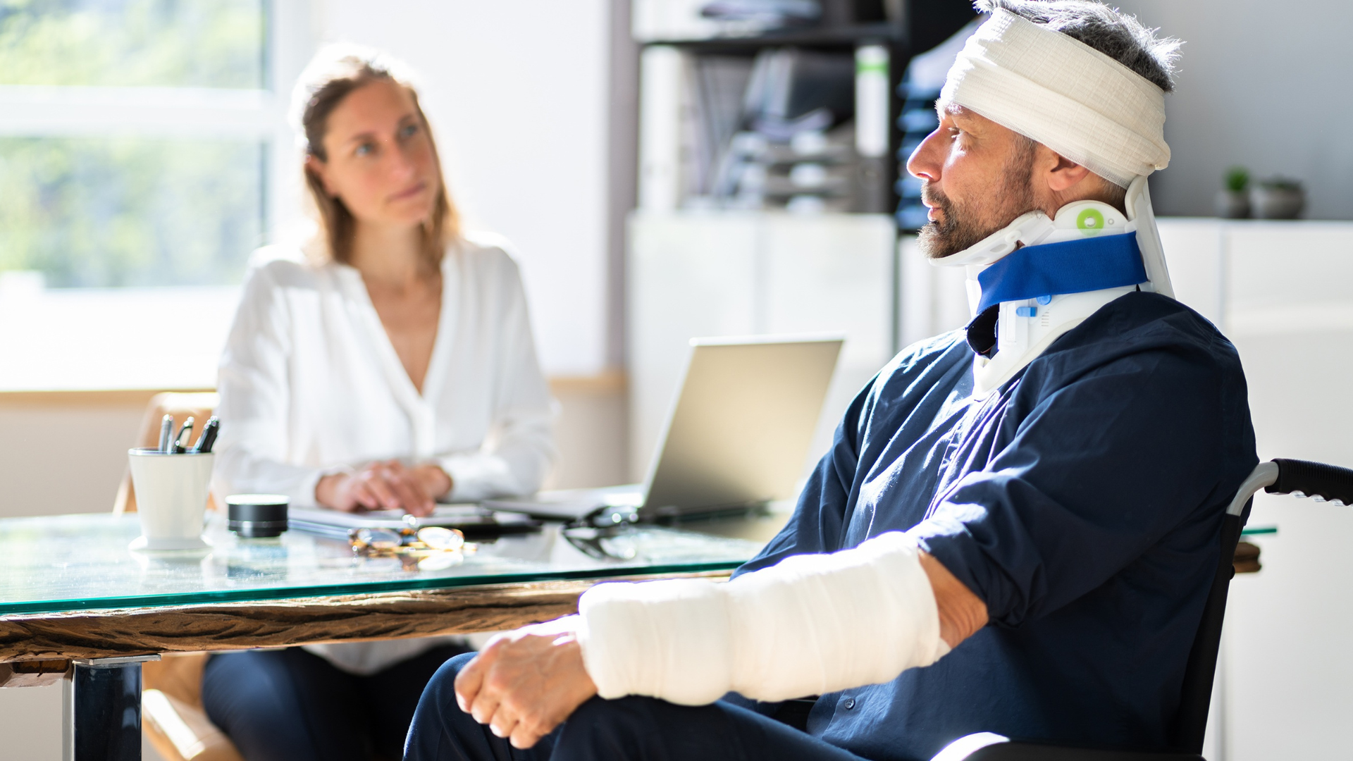 A man with a head injury and broken arm speaking with a doctor