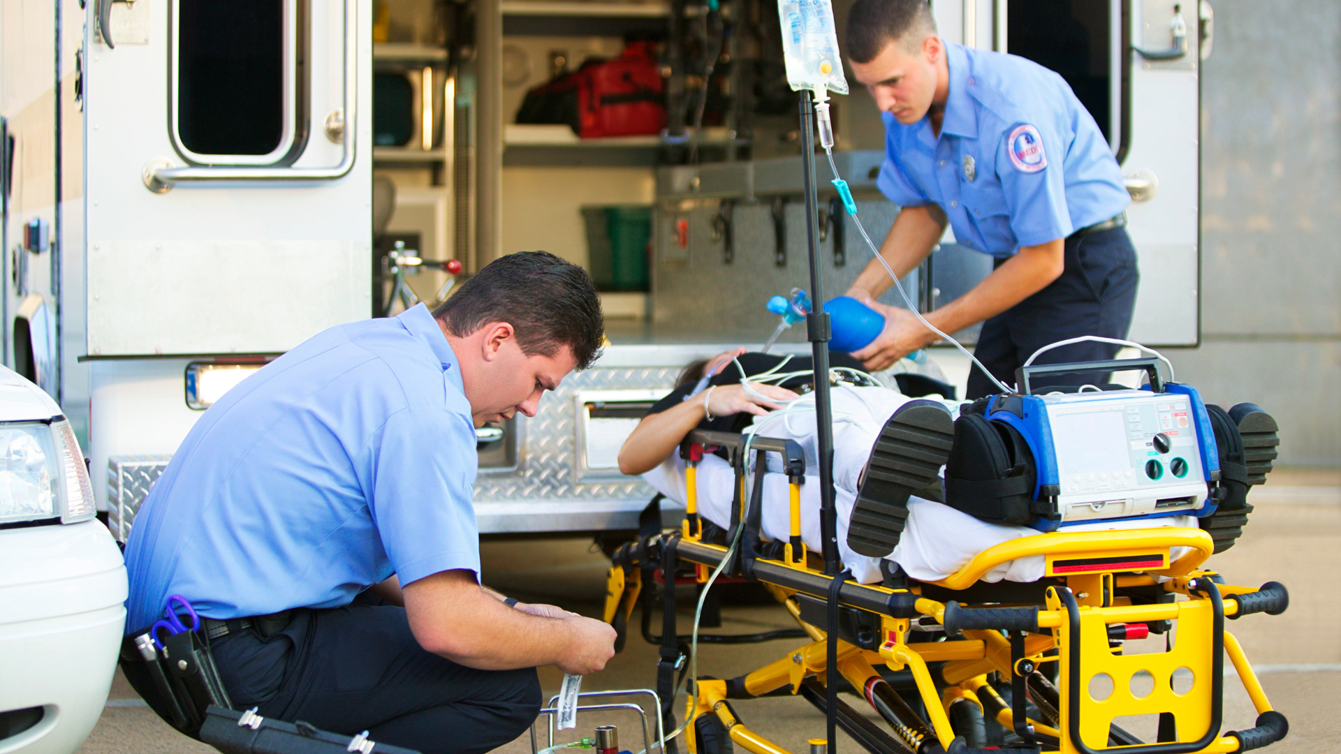 Paramedics working on an injured person on a gurney