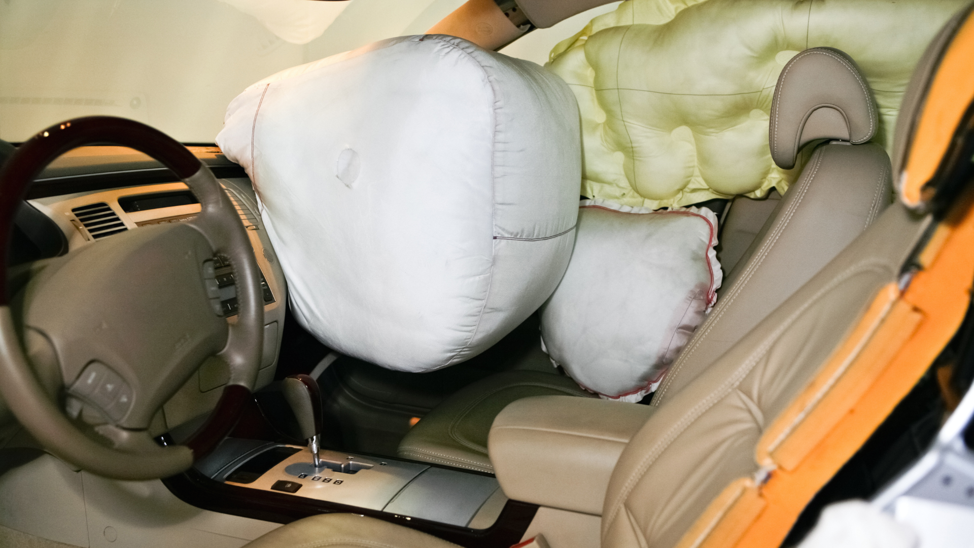Deployed airbag in crashed vehicle showing potential for auto defect injuries from malfunctioning safety systems