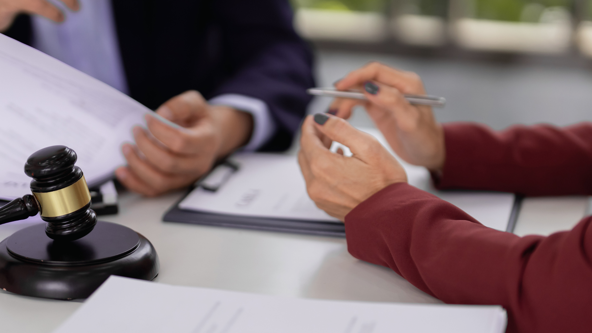 A lawyer at a desk with a gavel on it with a client