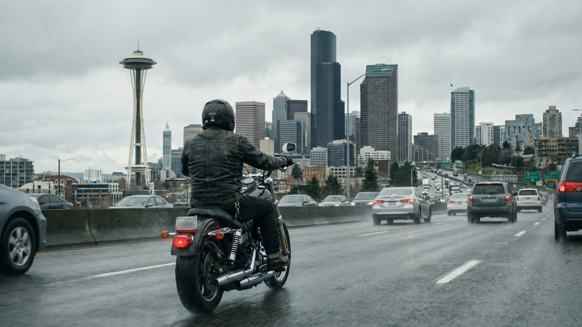 A motorcycle rider wearing a helmet riding towards Seattle on I-5