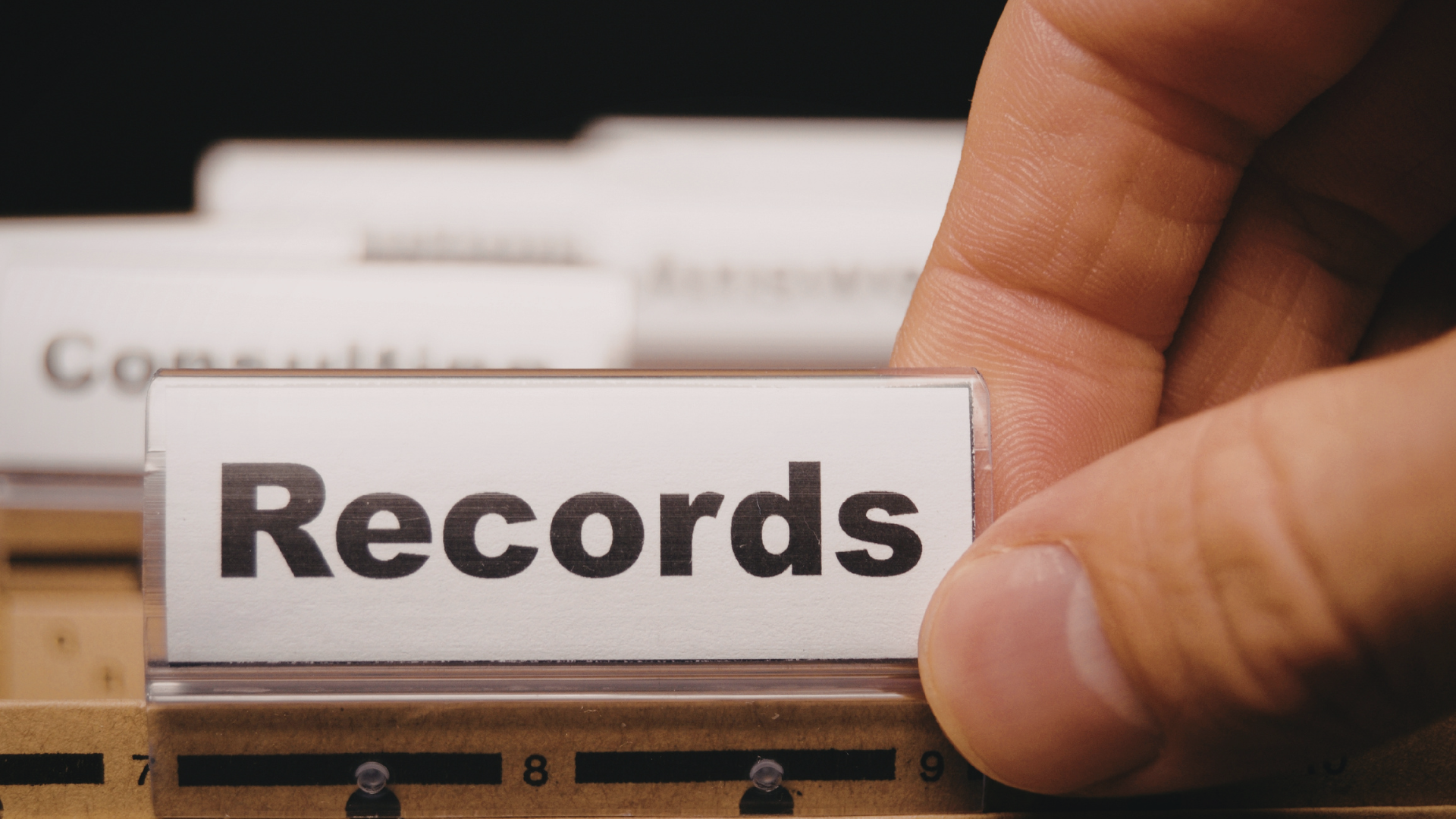 A hand grabbing a file folder labeled "Records"