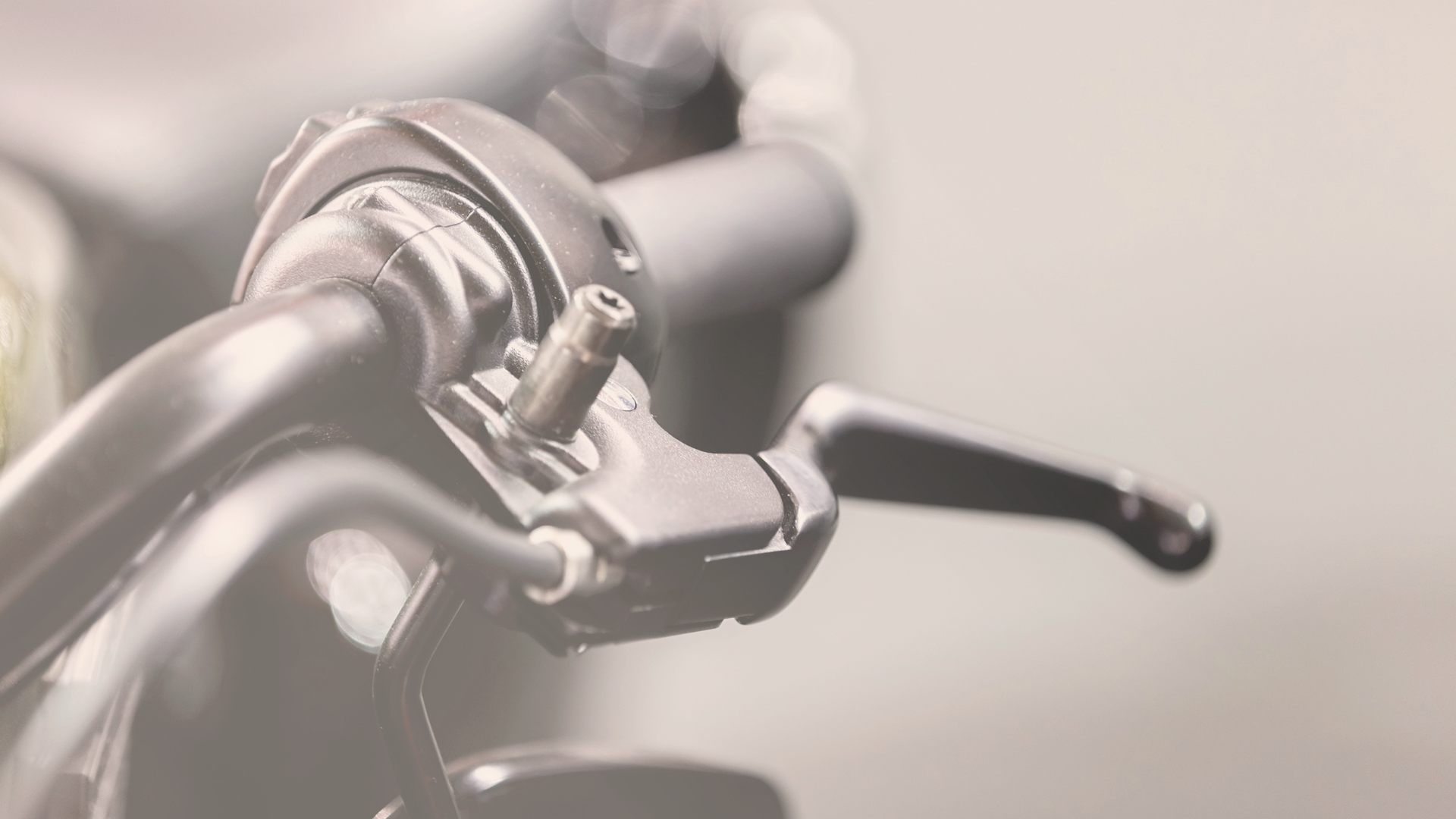 a sepia toned image of a motorcycle handlebar with a clutch lever