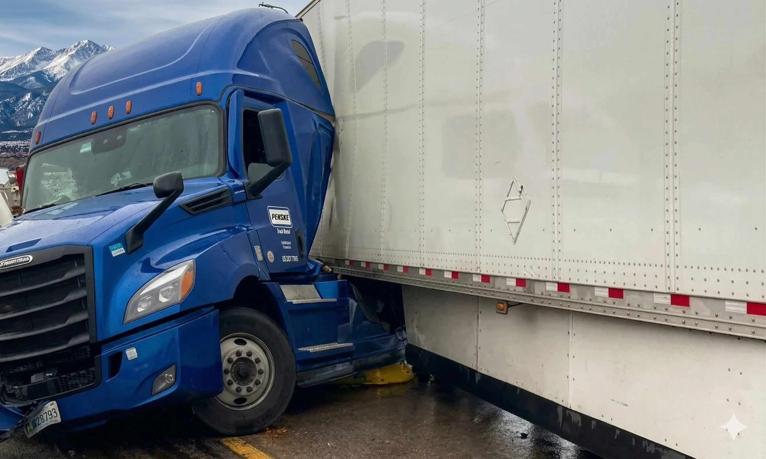 A blue semi truck that has jack-knifed into its trailer on a Colorado road