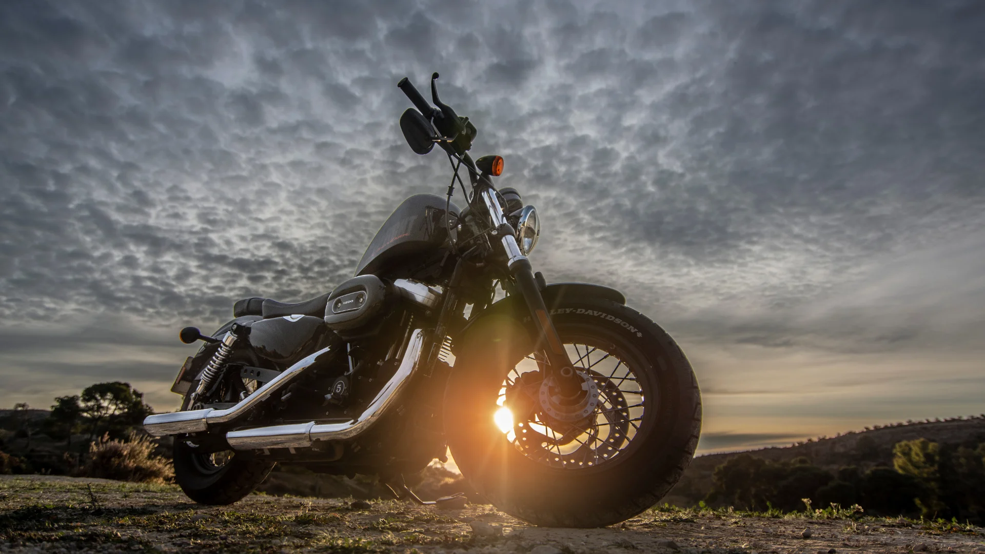 A motorcycle on the plains naar sunset with a cloudy sky