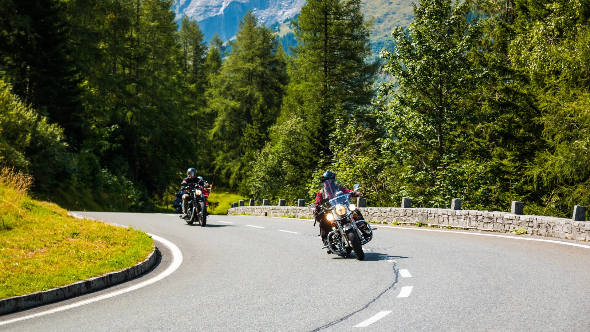 Two motorcycle riders on a forest highway