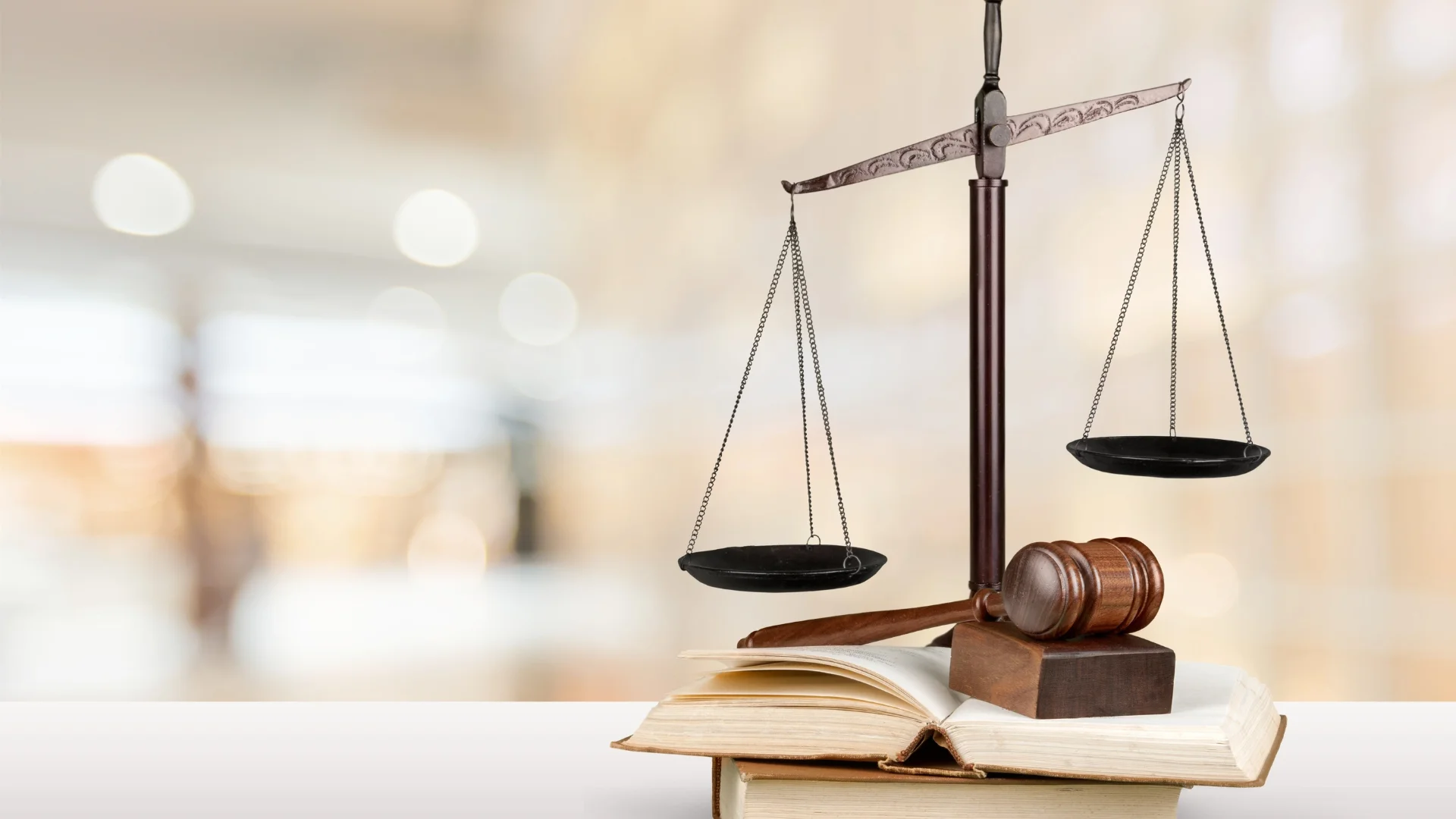 The scales of justice and a gavel resting on top of books on a desk