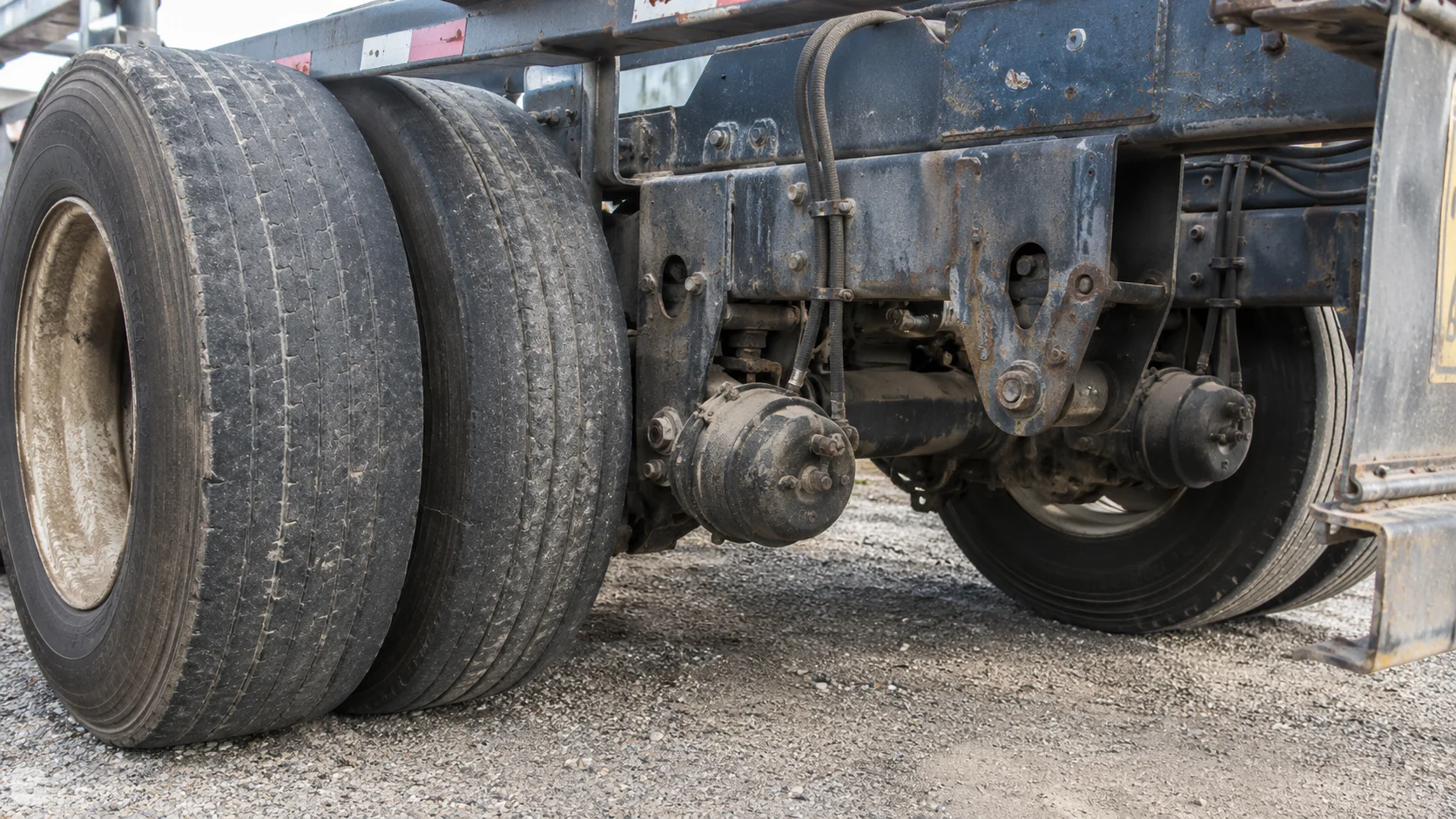 Worn tires and brakes on an intermodal container chassis, the kind of chassis defect that can cause a truck crash