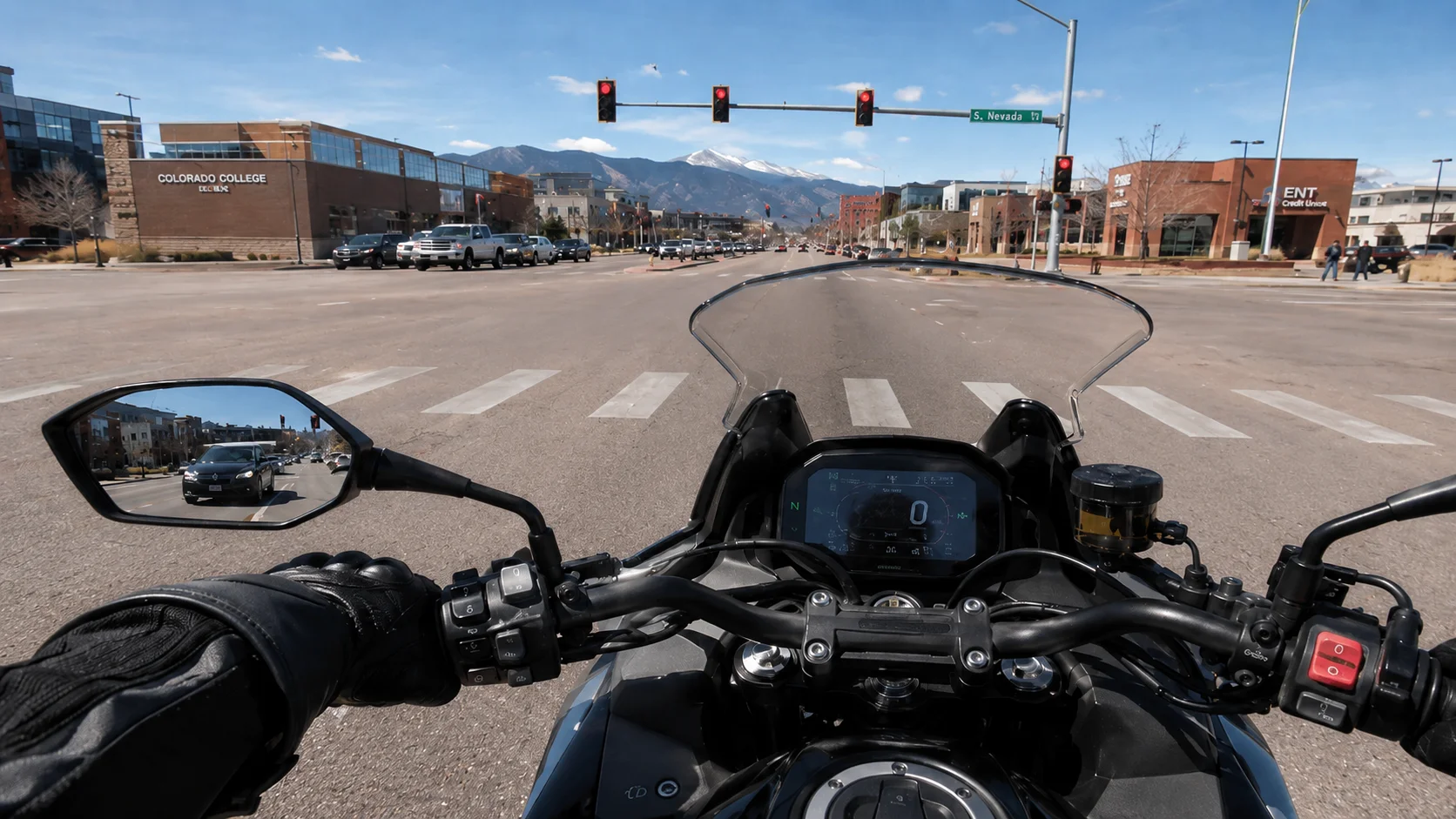 Motorcycle rider stopped at a Colorado Springs light watching traffic approach from behind