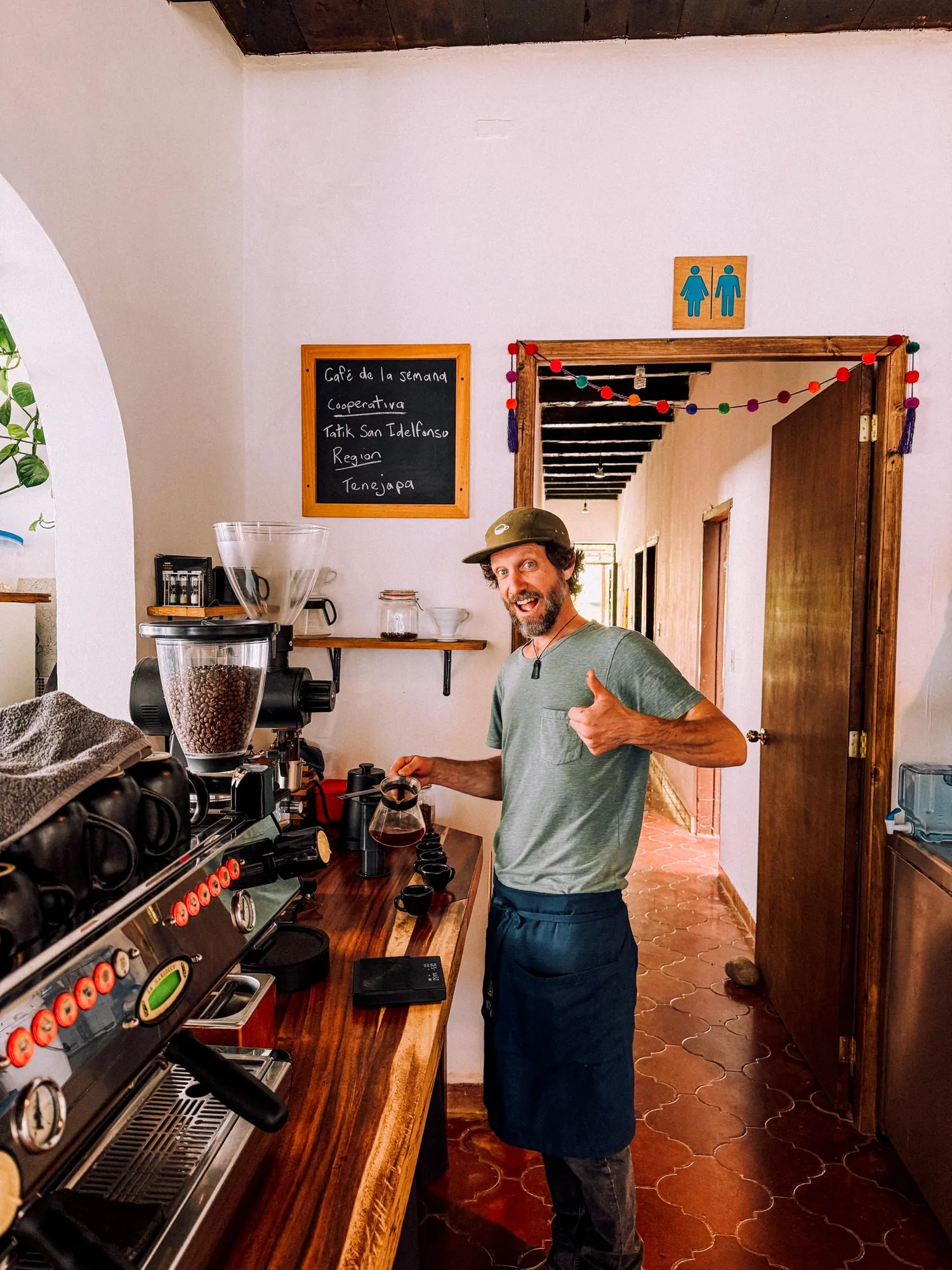 Barista in front of a chalkboard menu listing Chiapas coffees