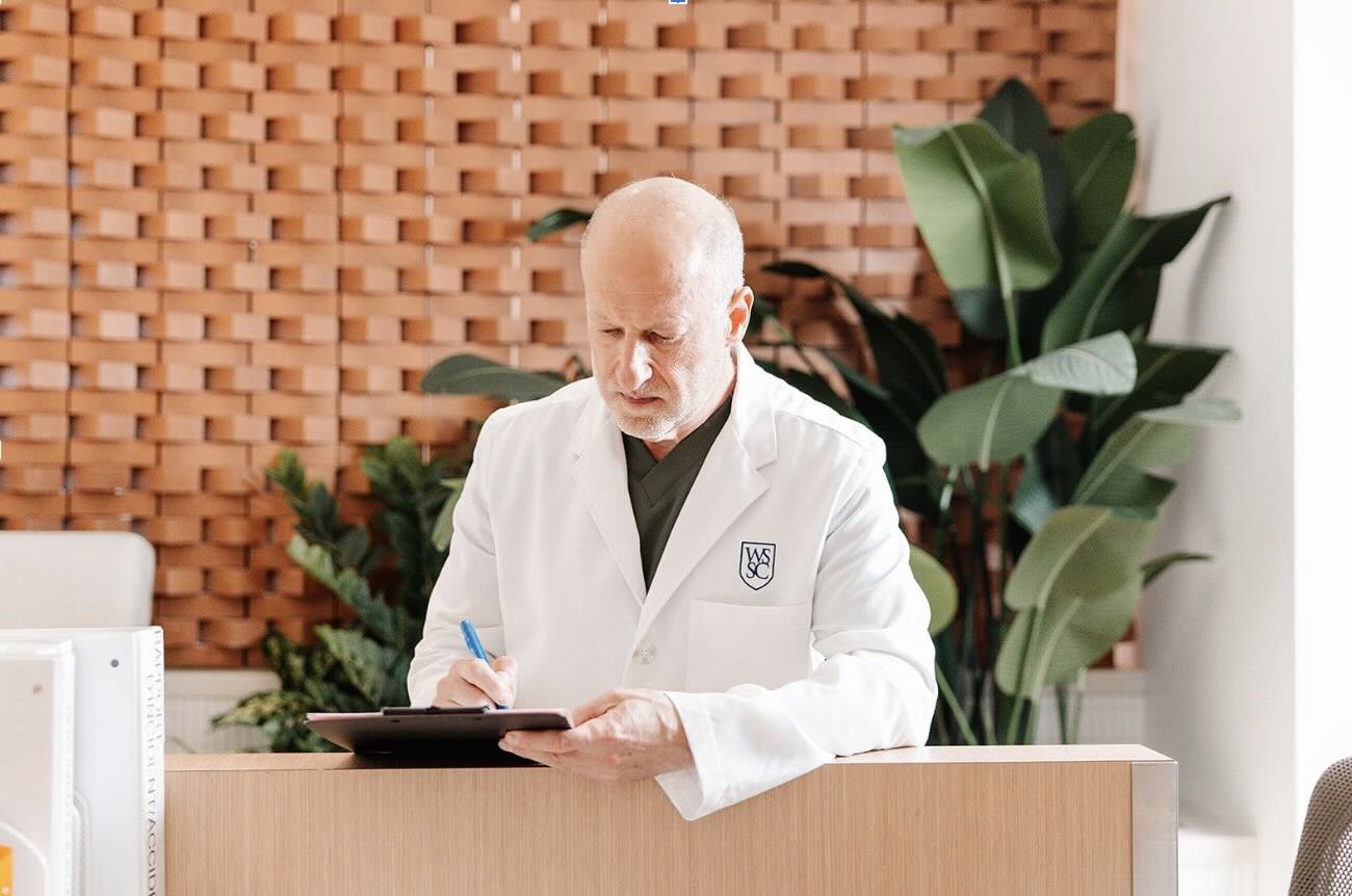 Dr. Eiley in the Uro Westmount office, writing on patient chart