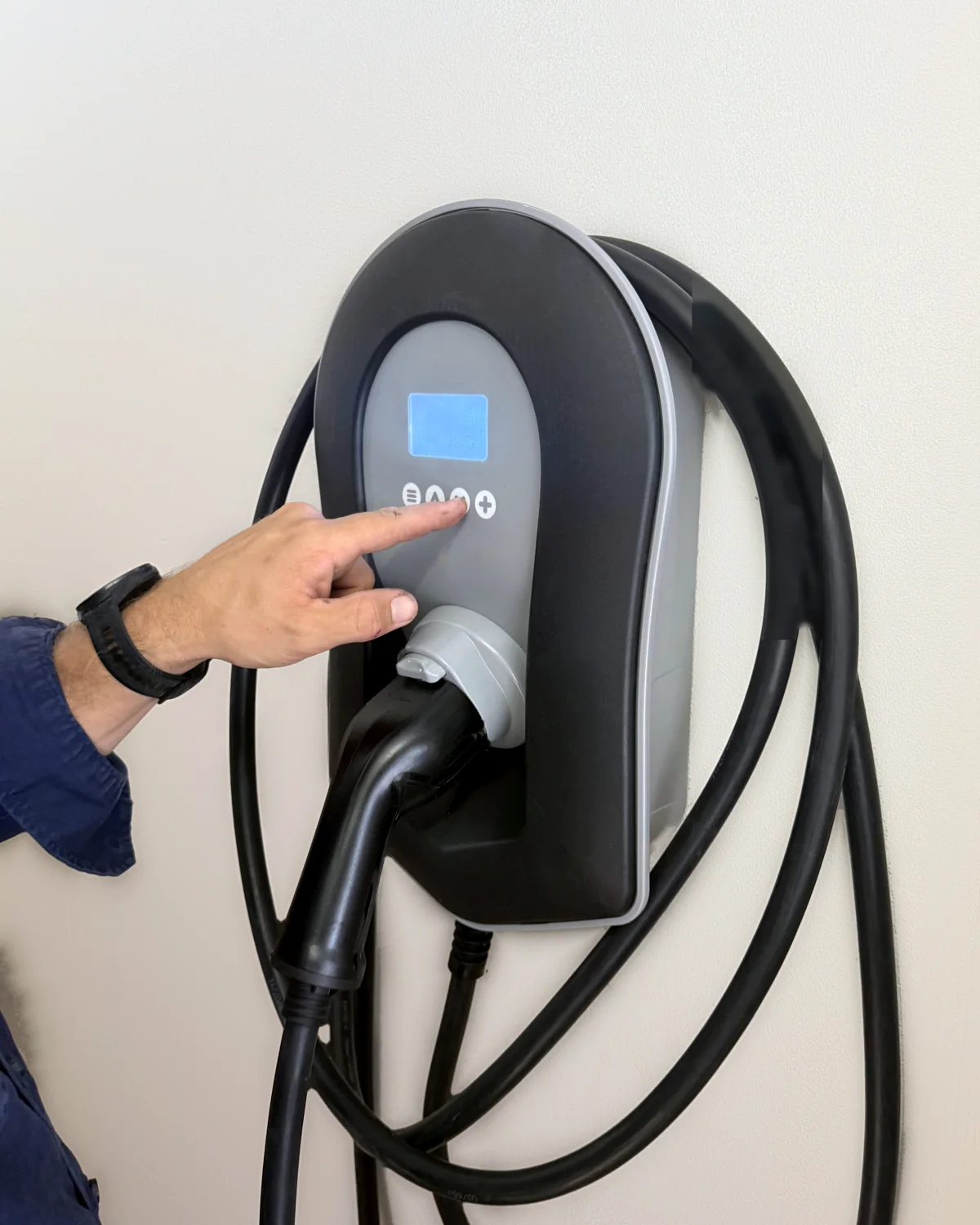 Electrician setting up a newly installed wall-mounted home EV charger in Sydney