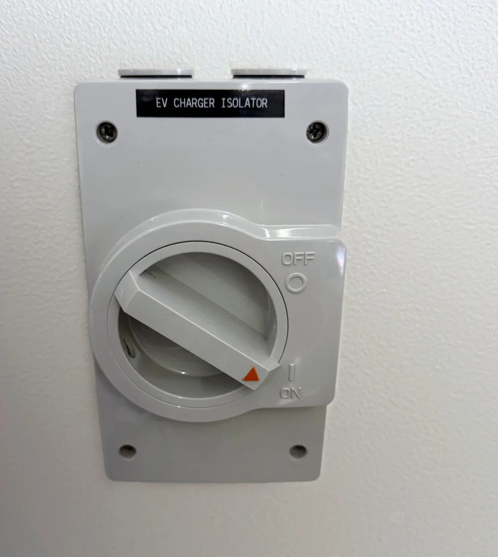 Labelled EV charger isolator switch installed on a wall