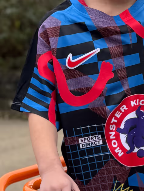 A closeup shot of a child wearing little monsters football kit