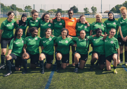 Female football team posing on a football pitch