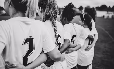 A black and white picture of female footballers on a field