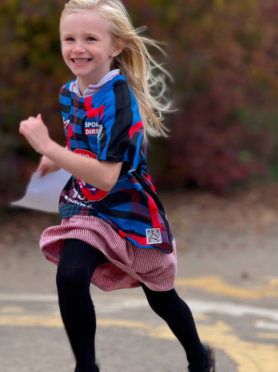 A photograph of a running and wearing little monsters football kit