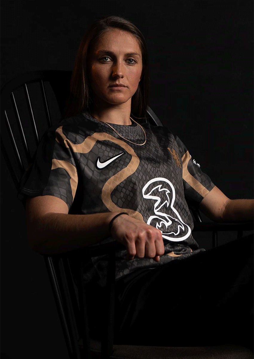 A woman wearing a black shirt with a bird on it.