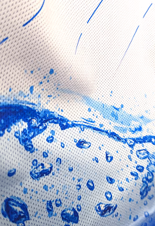 Close-up of a football shirt featuring a vibrant blue water splash and droplets graphic printed on white mesh fabric.