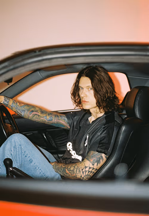 Male model sitting in a red sportscar