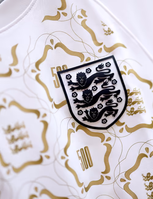 White fabric with black three lions crest and gold decorative patterns featuring the number 500.